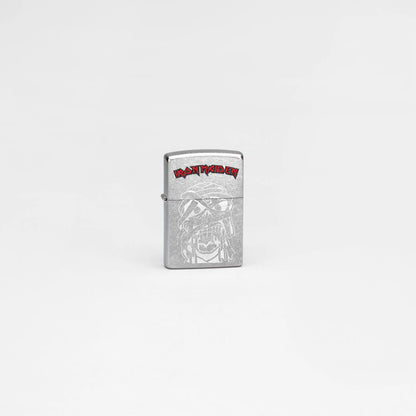 Lifestyle image of Zippo Iron Maiden Eddie Street Chrome Windproof Lighter in a grey scene.